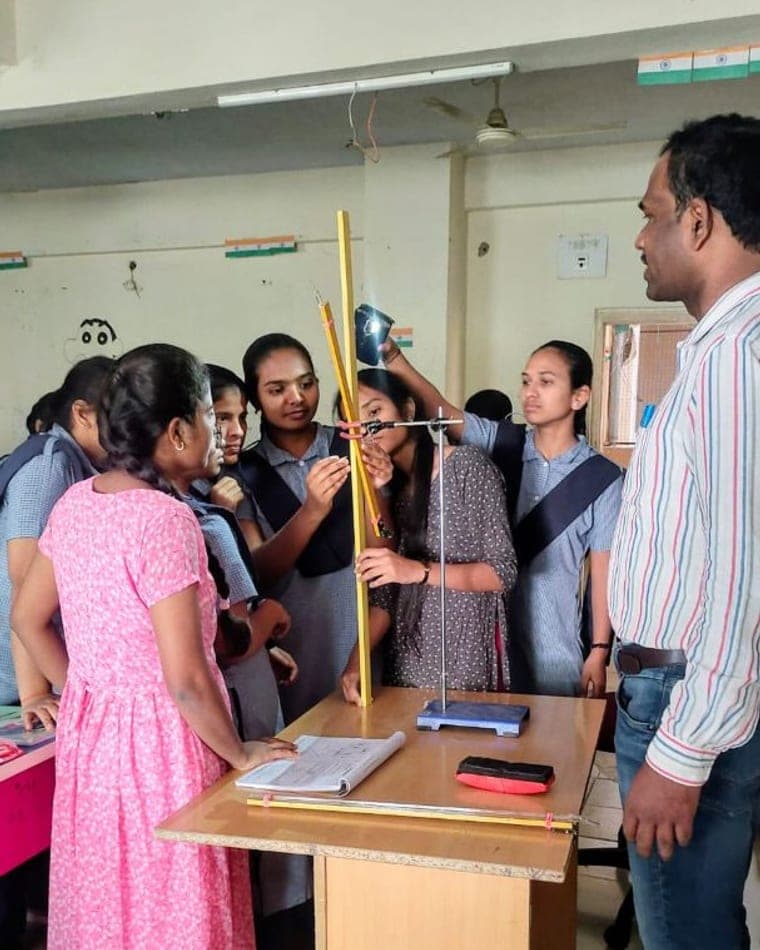 Dr Rajeshwar Reddy guiding students through a physics experiment on an optical bench